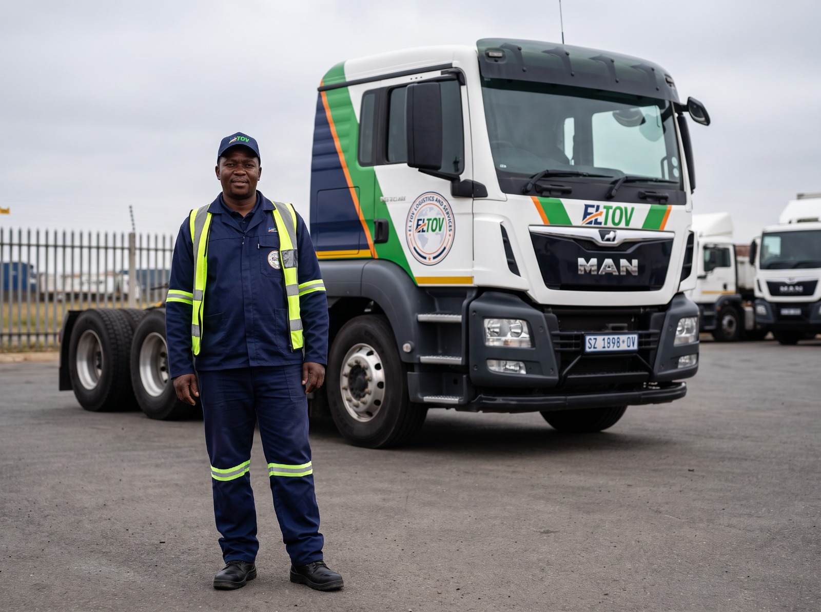 El Tov driver standing beside a branded MAN freight truck